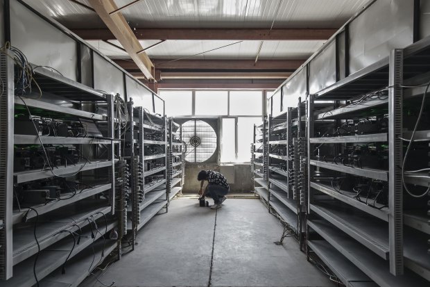 A technician inspects bitcoin mining machines at a mining facility in inner Mongolia.