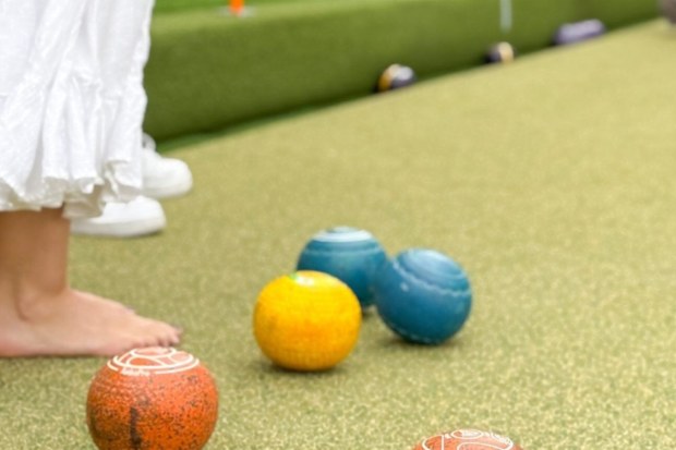  People playing barefoot bowls at Caringbah Bowling & Recreation Club. 