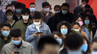 Commuters wear face masks to protect against the spread of new coronavirus as they walk through a subway station in Beijing, Thursday, April 9, 2020. China's National Health Commission on Thursday reported dozens of new COVID-19 cases, including most of which it says are imported infections in recent arrivals from abroad and two "native" cases in the southern province of Guangdong.  (AP Photo/Mark Schiefelbein)