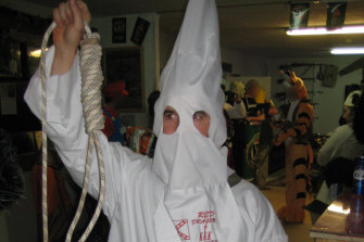 A soldier dressed in a Ku Klux Klan outfit at a party at the soldier’s bar, the Fat Ladies Arms.