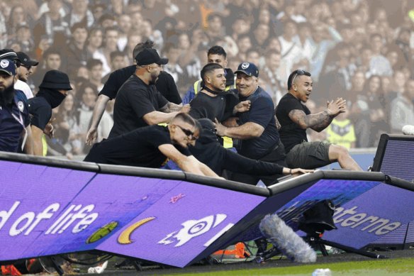 Victory fans invade the pitch at the Melbourne derby.