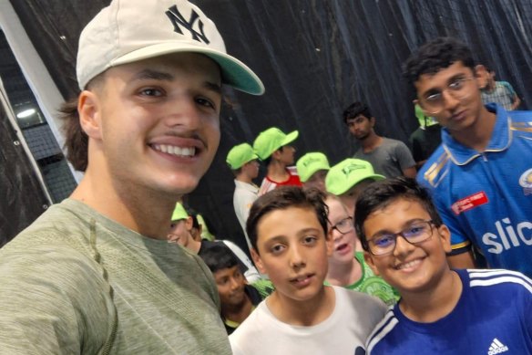 Konstas poses for a snap with Shahzad Muhammad Khan (white shirt) after the boy’s father crashed his car trying to help get a photo with the Sydney Thunder star.