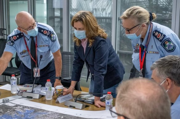 Premier Annastacia Palaszczuk being briefed on the flood situation on Saturday. The Health Department said the floods had affected the reporting of COVID figures.