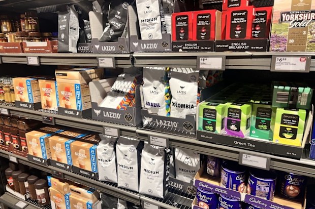 Bags of coffee beans in various packaging in a supermarket.