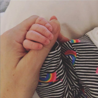 Holding the hand of her son Max earlier this month.