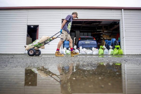Taine Donnelly removes sand bags at St Peters College in Gore, NZ, after the flood on Friday.