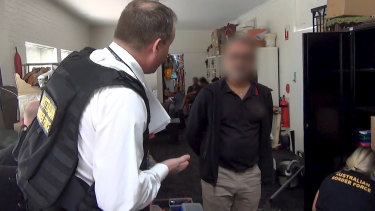 An Australian Border Force officer questioning the arrested man