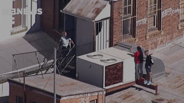A man and woman in a tense standoff with police on an Ipswich roof.