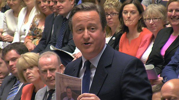 David Cameron displays a photo of himself and Larry the government's  Chief Mouser during a lighthearted final session of prime minister's questions before he resigned.