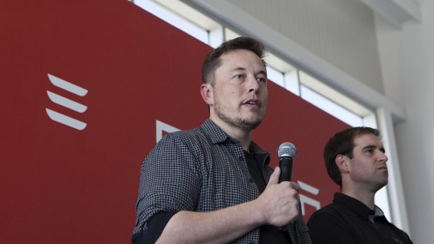 Elon Musk speaks as JB Straubel looks on. 