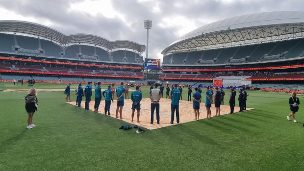 Australia and West Indies players take part in a barefoot circle.