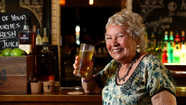 Merle Thornton, who chained herself to the bar at the Regatta Hotel on March 31, 1965, poses with a pint of beer at the same bar 50 years on in March 2015.