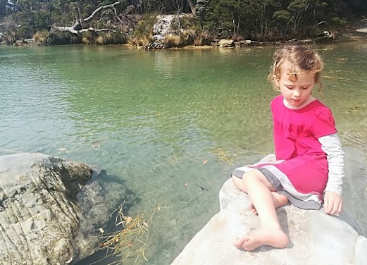 Maggie sitting by the water in Tasmania.