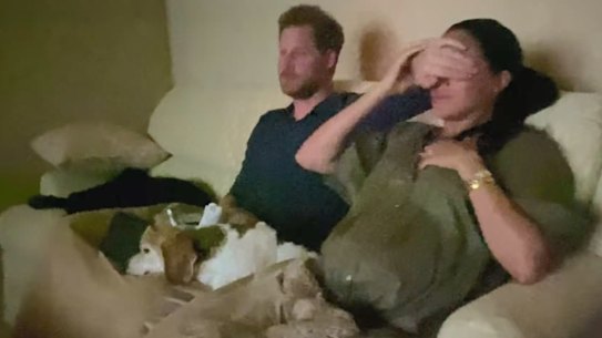 Harry covers the eyes of his wife Meghan, as they watch their interview with Oprah Winfrey.