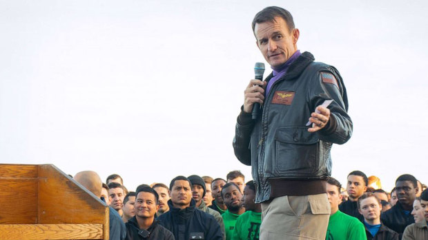 Captain Brett Crozier, commanding officer of the aircraft carrier USS Theodore Roosevelt gives remarks during an all-hands call on the flight deck in December. 