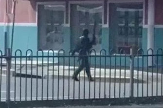 Bystander video shows a man dressed all in black and armed with two firearms on Windang Road. 