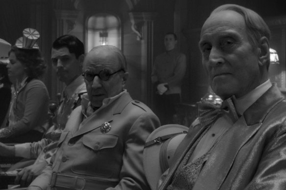 Arliss Howard, centre, and Charles Dance, right, appear in a scene from "Mank".