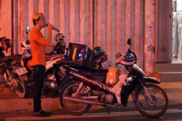 A Ho Chi Minh City local belts out a tune on the street. 