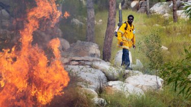 An Indigenous rangers controls a wildfire in Kakadu.
