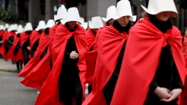 Women in favour of a measure to expand legal abortions wear red cloaks and white bonnets like the characters from The Handmaid's Tale.