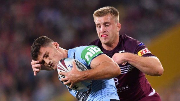 Nathan Cleary (left) is collared by opposing Maroons half Cameron Munster.