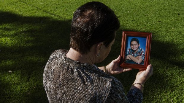 Mohammed Noor Masri's mother holds a photo of her son taken in 2002. 