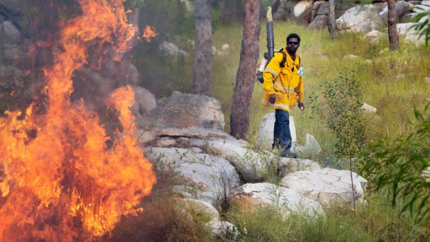 An Indigenous rangers controls a wildfire in Kakadu.

