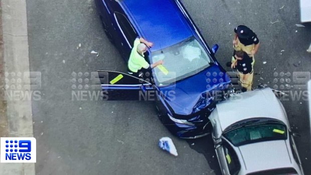 The stolen car (white) and police car crashed head-on in the Gold Coast suburb of Coomera on Thursday morning.
