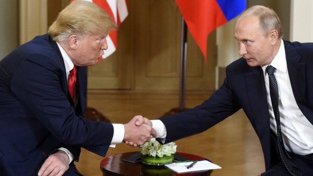 Donald Trump and Vladimir Putin shake hands before heading into a private meeting.