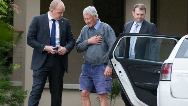 Bill Spedding, centre, is arrested at his Bonny Hills home in April 2015. 