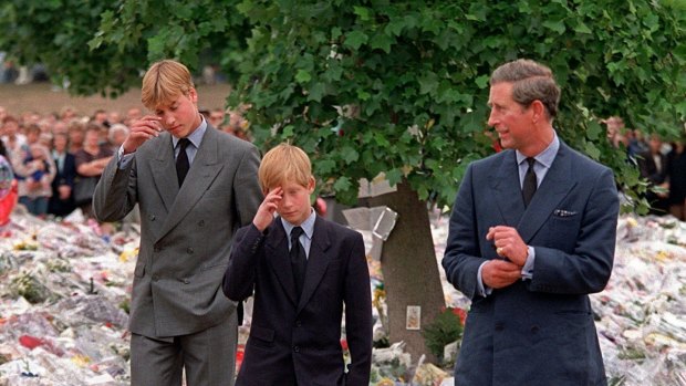 Charles, then the Prince of Wales, accompanies his sons Prince William (left) and Prince Harry to view flowers left in memory of Diana. 