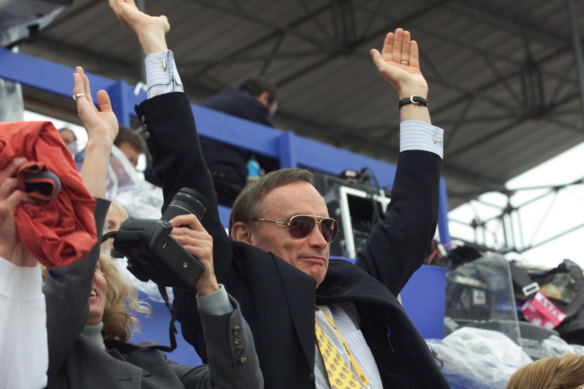 Bob Carr performs the Mexican wave at the beach volleyball at Bondi during the Olympics.