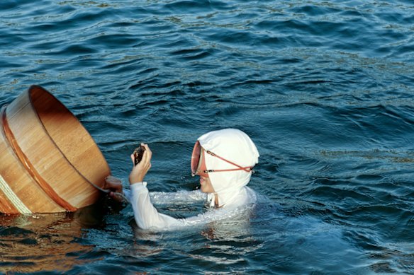 A diver adds an abalone to her floating basket during a demonstration at Mikimoto Pearl Island.