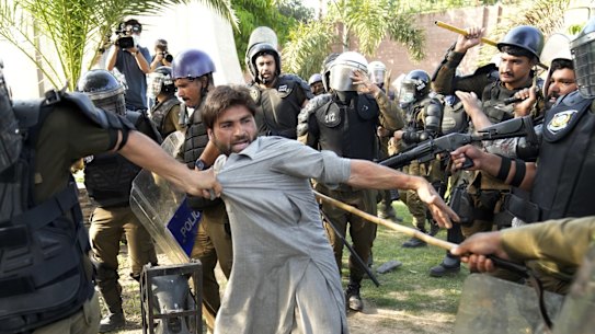 Police detain a supporter of Imran Khan in Lahore.