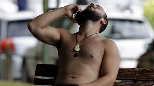 A man reacts as he speaks on a mobile phone outside a mosque in central Christchurch, New Zealand on Friday. 
