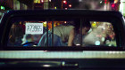 The gold hoop earrings on a young girl glimmer as she slides across the cab of a pickup truck: one of the images from the series ‘The Liquid Night’.