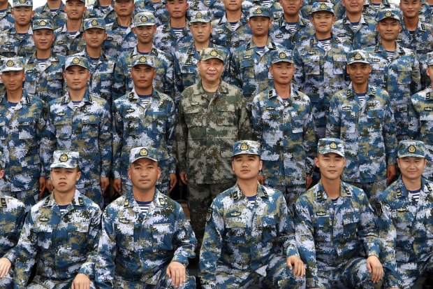 Xi Jinping (centre, in green military uniform) with members of the People’s Liberation Army (PLA) on a naval ship in the South China Sea in 2018.