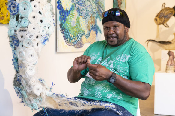 An artist showcases ghost net art at the Cairns Indigenous Art Fair.