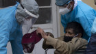 The world is waiting on a vaccine. A man found lying outside a hospital in La Paz, Bolivia, is loaded into a wheelchair to be taken into a clinic that treats suspected COVID-19 patients.