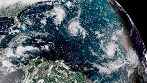 This enhanced satellite image made available by NOAA shows Tropical Storm Florence, centre, in the Atlantic Ocean on Saturday.