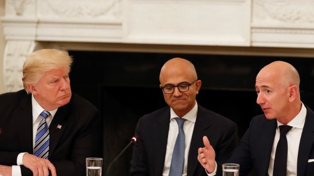 Powerful opponent: Donald Trump (with Microsoft CEO Satya Nadella in the centre) has repeatedly attacked Jeff Bezos' Amazon.