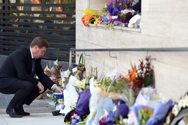 NSW Police Minister Troy Grant looks at flowers placed for police employee Curtis Cheng outside of the NSW Police Headquarters in Sydney on Tuesday, Oct. 6, 2015. Mr Cheng died at the scene after being shot by 15-year-old gunman Farhad Jabar Khalil Mohammad, was killed by officers responding to the shooting.