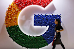 In this Monday, Nov. 5, 2018, file photo, a woman walks past the logo for Google at the China International Import Expo in Shanghai.