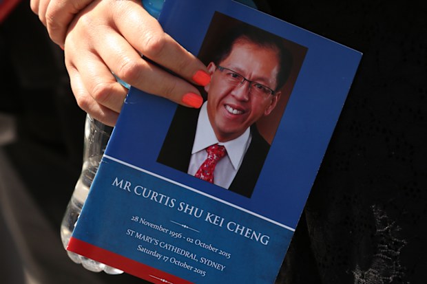 A woman holds an order of service for Curtis Cheng after his funeral service at St Mary's Cathedral, Sydney. Saturday, Oct. 17, 2015.
