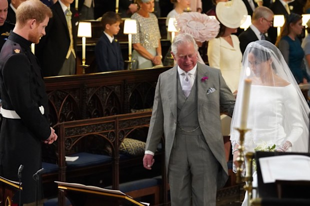 Britain's Prince Harry looks at his bride, Meghan Markle, as she arrives accompanied by the Prince Charles during the wedding ceremony of Prince Harry and Meghan Markle at St. George's Chapel in Windsor Castle in Windsor, near London, England, Saturday, May 19, 2018