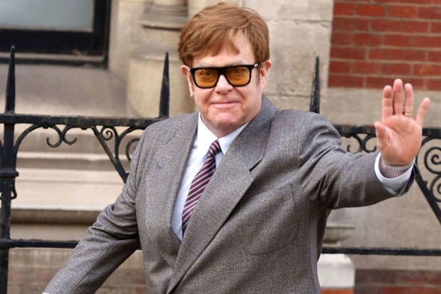 Elton John waves outside the Royal Courts of Justice in London, England