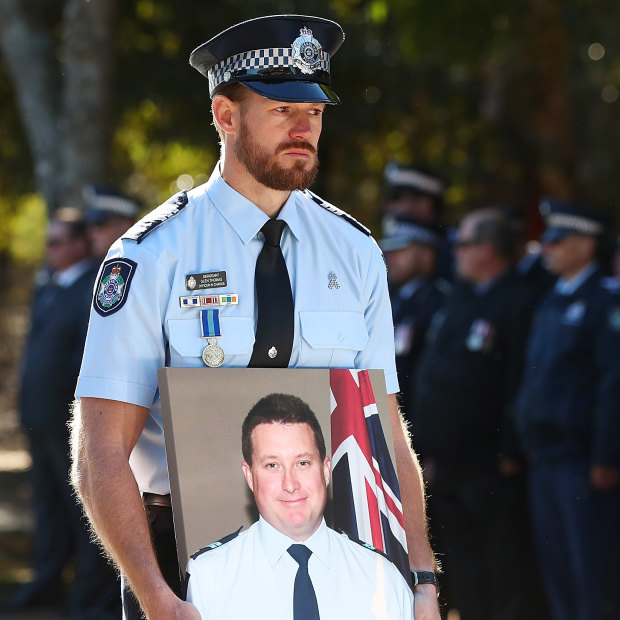 Sergeant Glen Thomas holds a photograph of Senior Constable Brett Forte during the fallen officer’s funeral in Toowoomba on June 7, 2017.