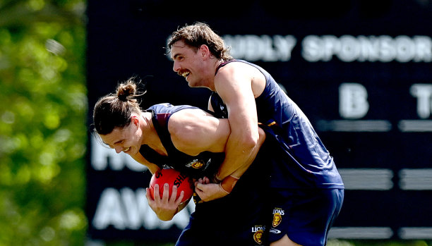 Eric Hipwood, left, and Joe Daniher, right, wrestle for the ball at Brisbane training on Wednesday. 