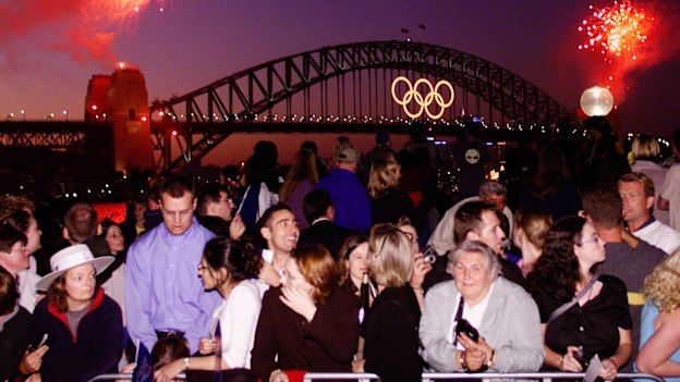 Crowds at the Sydney Opera House watch the Olympic Rings light up the Sydney Harbour Bridge. 