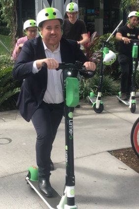 Lime director of government and policy Mitchell Price (front) scoots for joy after the company hit a million rides during its first six months in Brisbane.